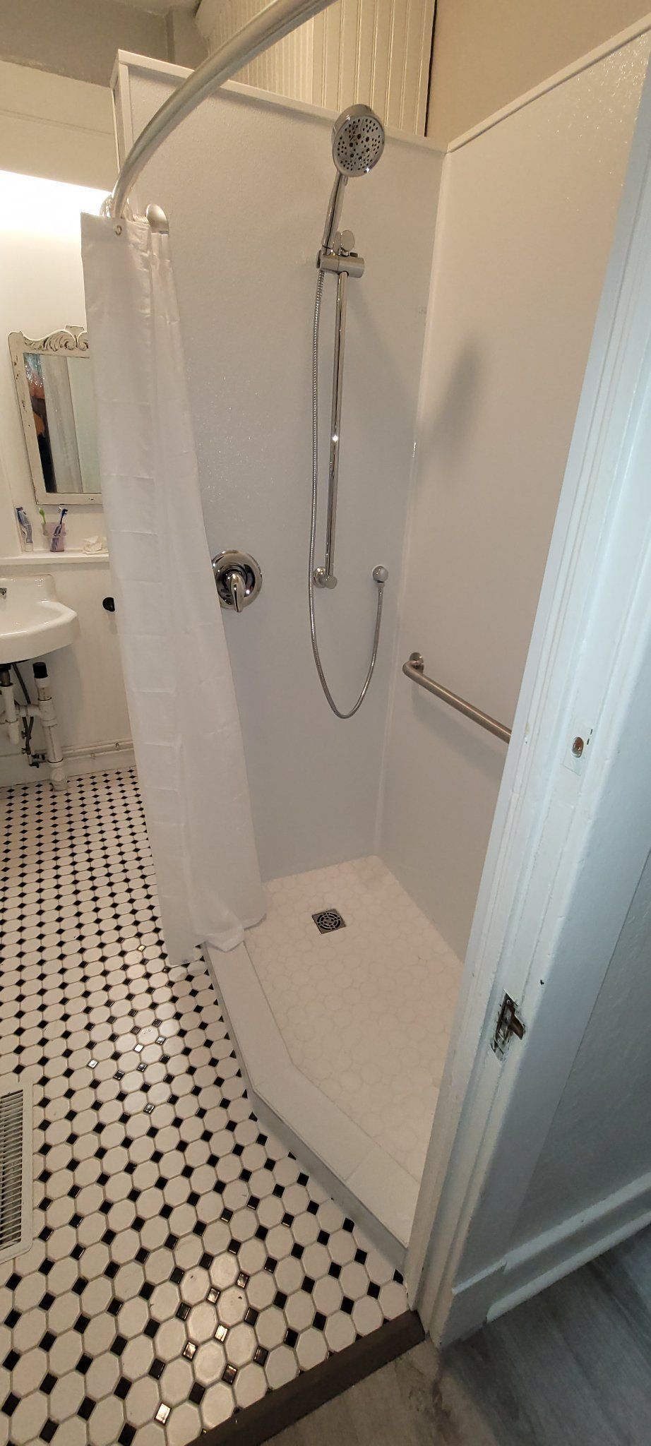A bathroom with a walk in shower and a sink