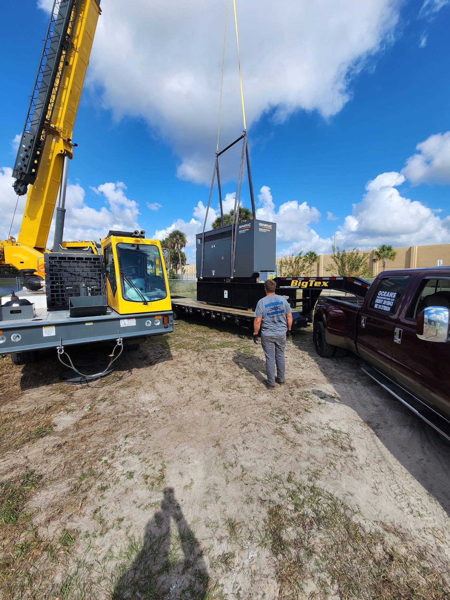Construction site with wooden forms, metal scaffolding, and workers. Palm trees and blue sky background.