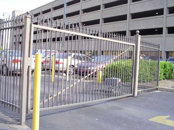 A parking lot with cars parked behind a gate