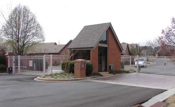 A brick building with a roof and a gate in front of it