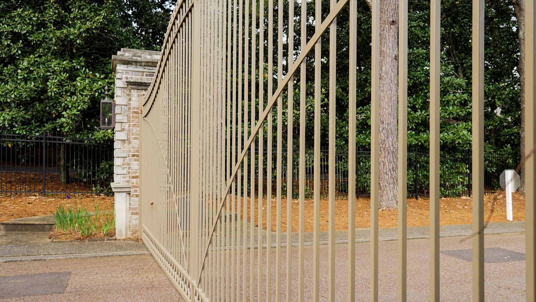 A close up of a metal fence with trees in the background.