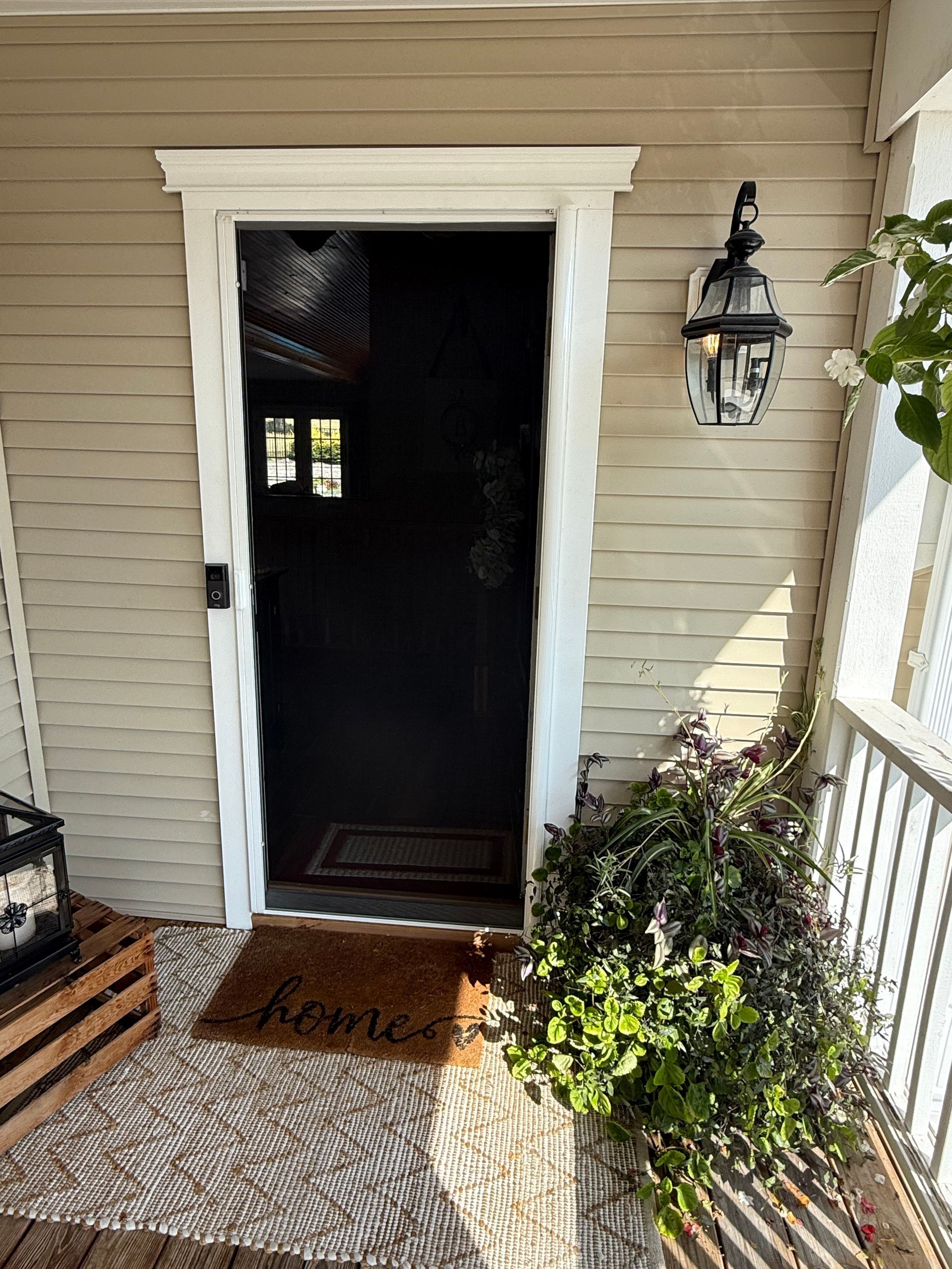 Beige house entrance with white trim, black door