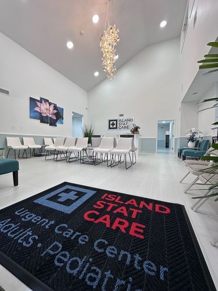 Entrance to Island Stat Care urgent care. Waiting area with seating, welcome mat, and logo.