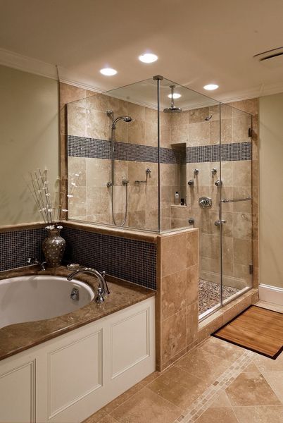 Luxurious bathroom with a glass-enclosed shower, soaking tub, and beige and blue tile.