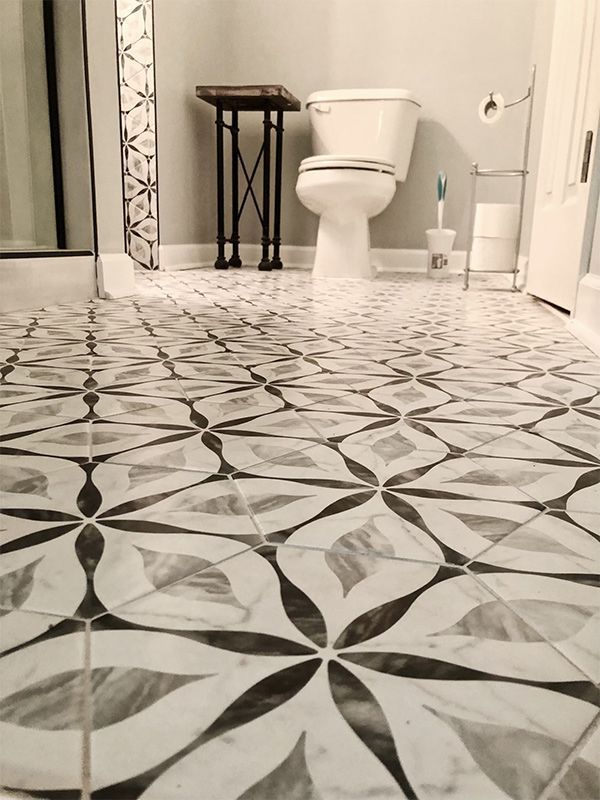 A bathroom with a toilet and a black and white tile floor