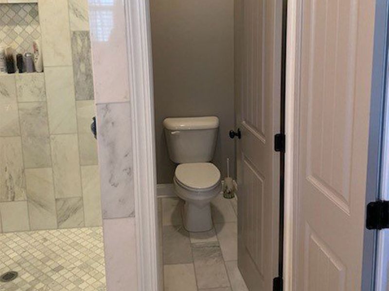A bathroom with a toilet and a walk in shower.