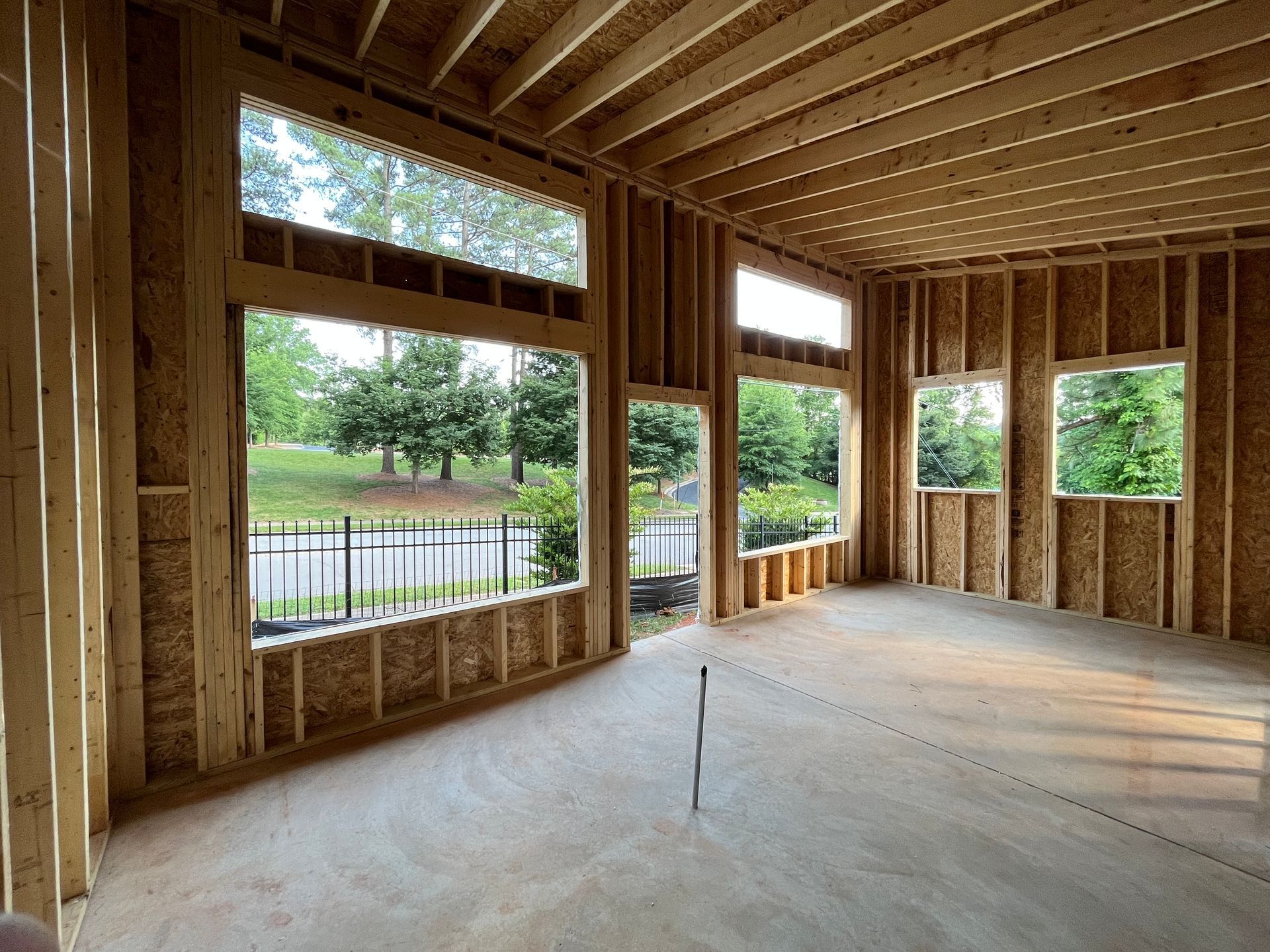 An empty room with a lot of windows and a fence in the background.