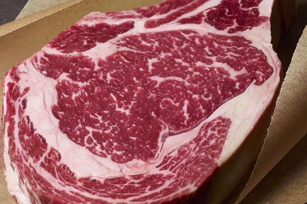 a large piece of raw beef is sitting on top of a piece of paper .