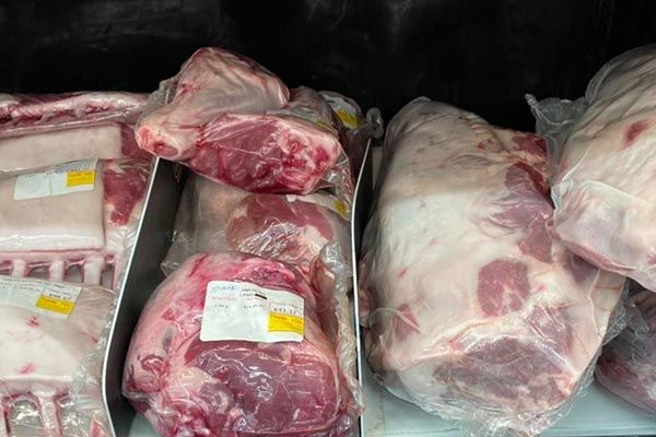 a bunch of meat is sitting on a shelf in a refrigerator .