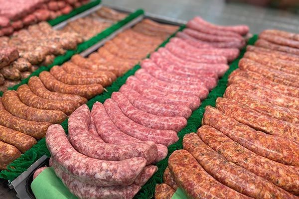 there are many different types of sausages on display in a butcher shop .