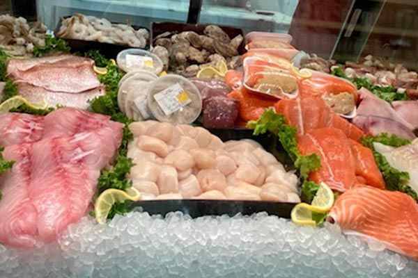 a variety of seafood is displayed on ice in a store .