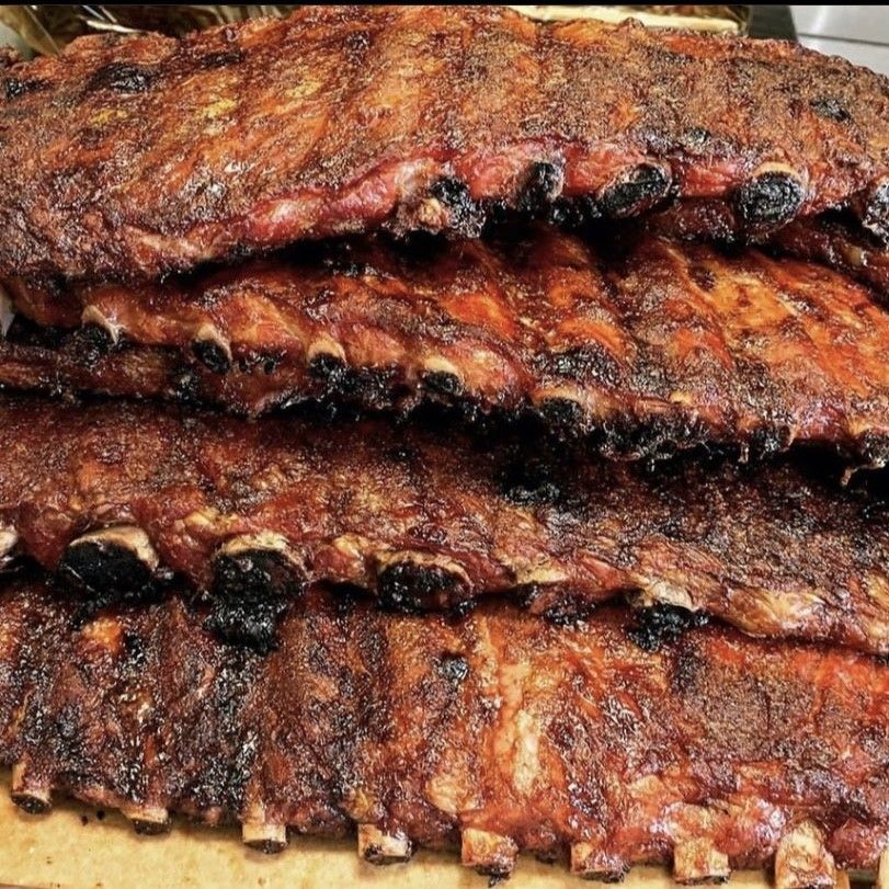 the ribs are stacked on top of each other on a wooden cutting board .