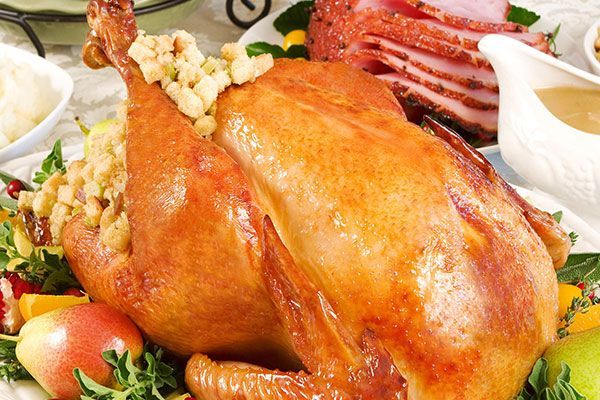 A roasted turkey is sitting on top of a plate of food.