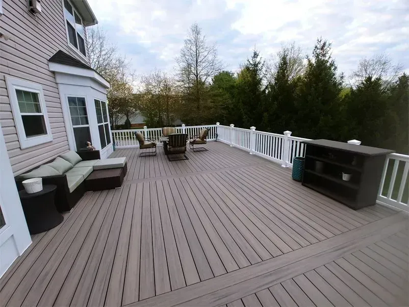 Spacious backyard deck with seating and storage, next to a house.