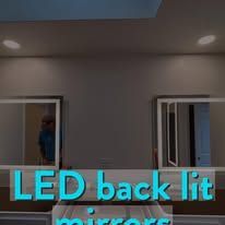 Two LED back lit mirrors on wall.