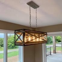 Rustic rectangular chandelier with exposed bulbs hanging above a well-lit living space.