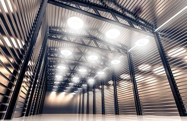 Empty, brightly lit warehouse interior with a metal frame and corrugated metal walls.
