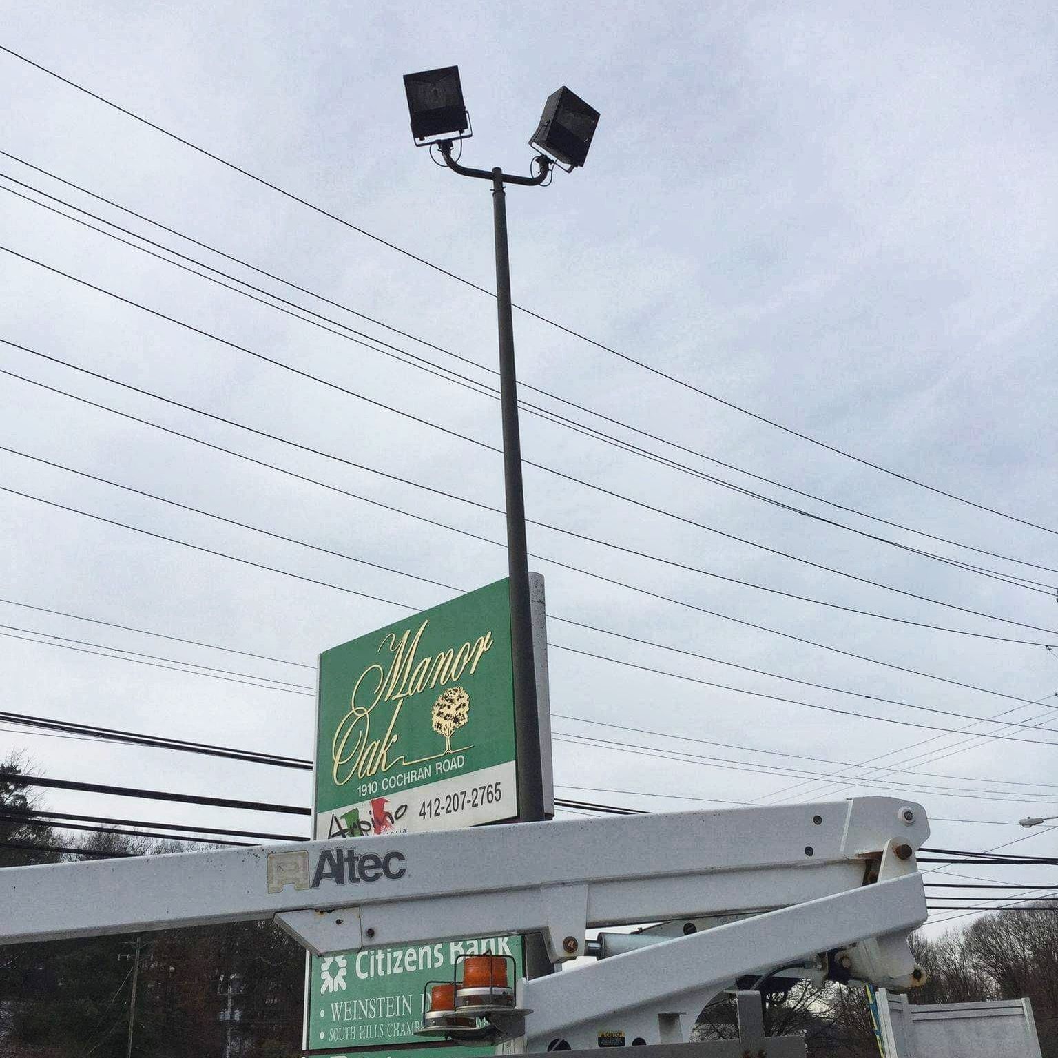 Sign for Ahonger Cafe with floodlights, atop an aerial lift.