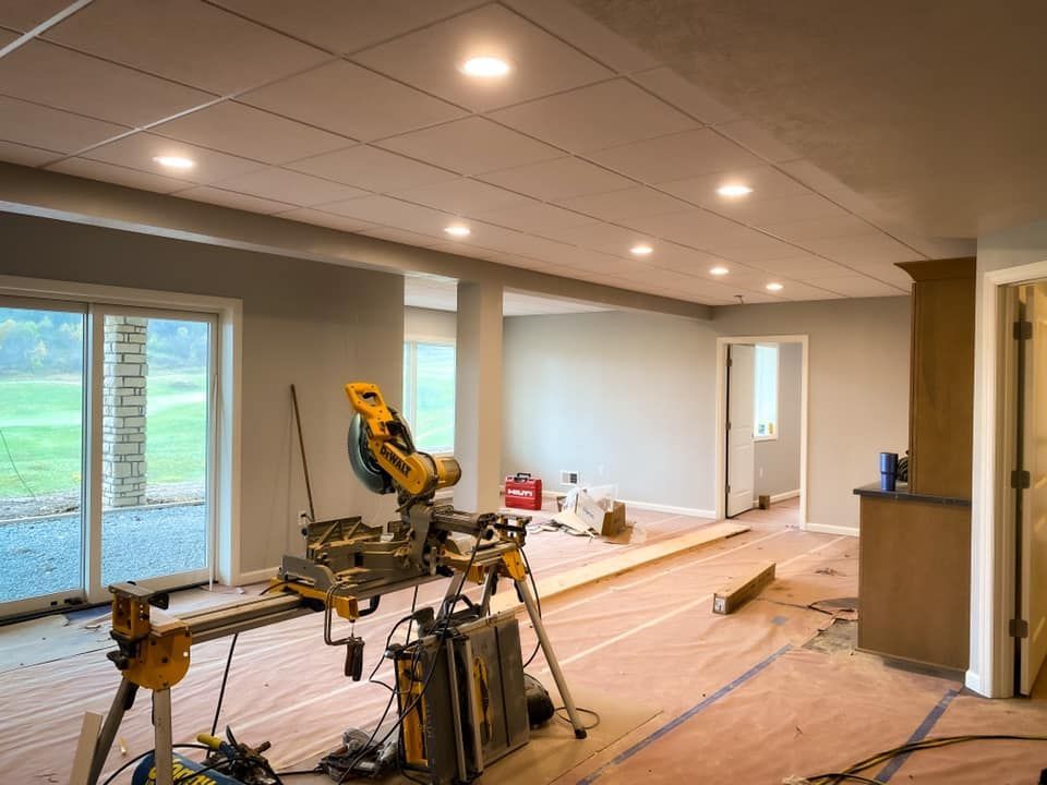 Interior construction site with miter saw, recessed lighting, and partially finished walls.