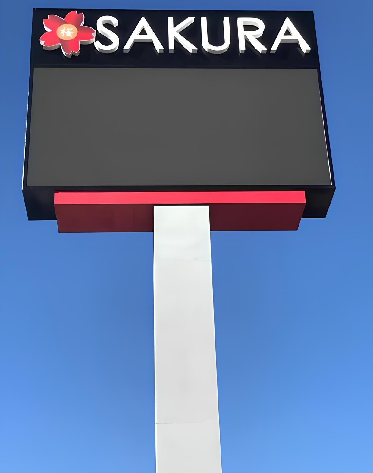 A large sakura sign against a blue sky.