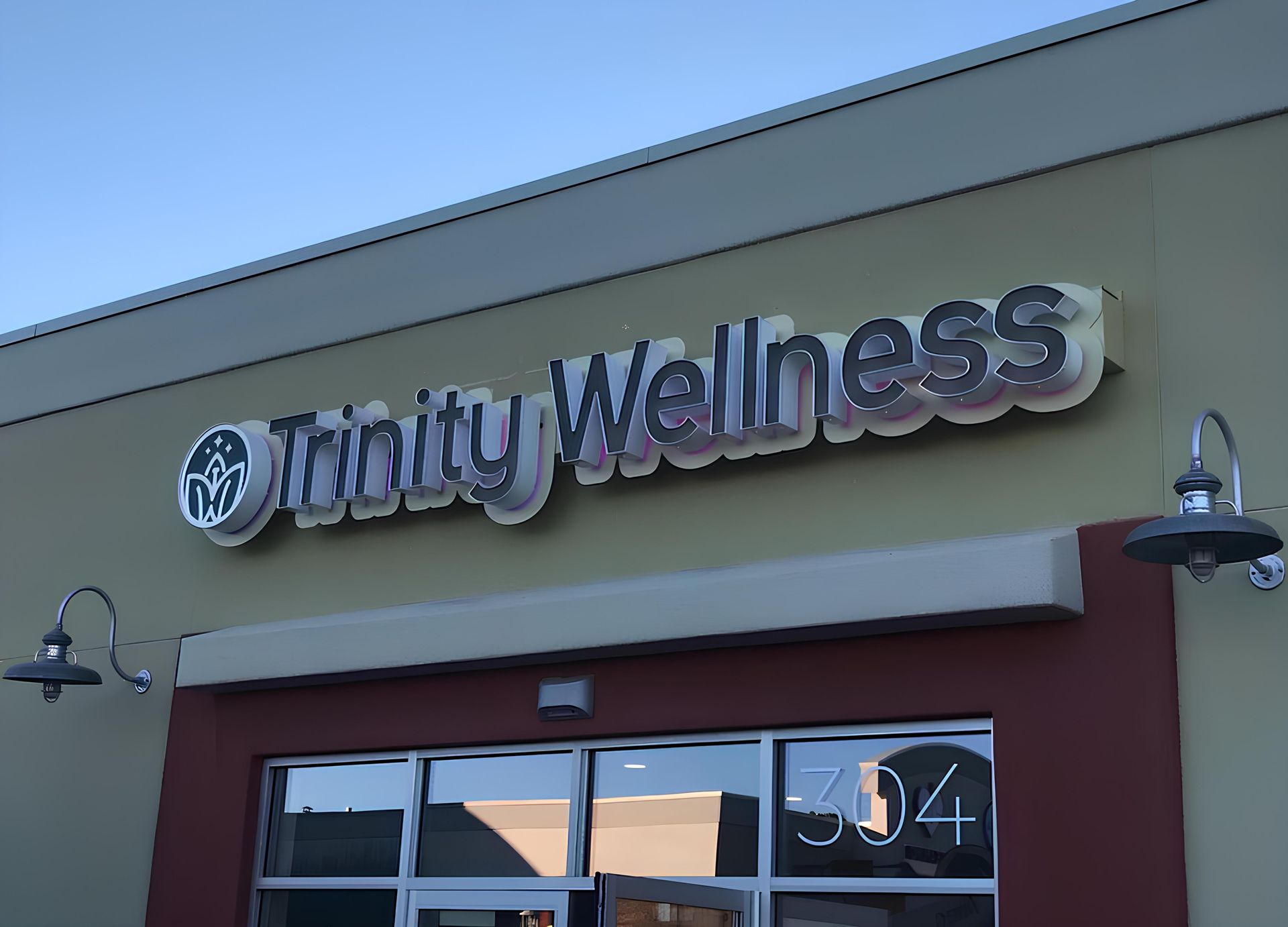 A trinity wellness sign is above the door of a building