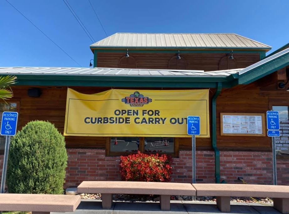 A restaurant with a sign that says open for curbside carry out.