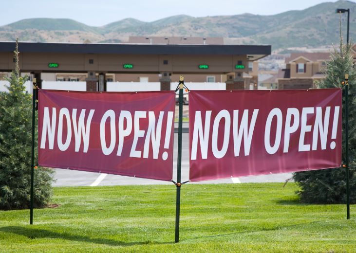 A red banner that says now open on it.