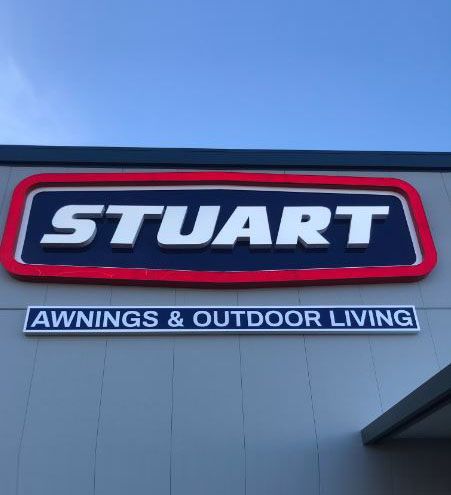 A stuart awnings and outdoor living sign on a building.