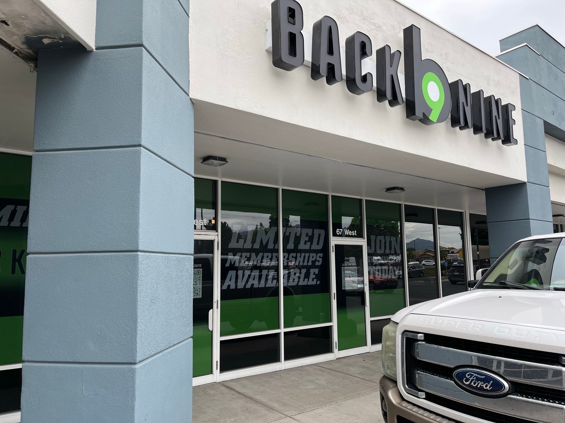 A ford truck is parked in front of a backbone store.