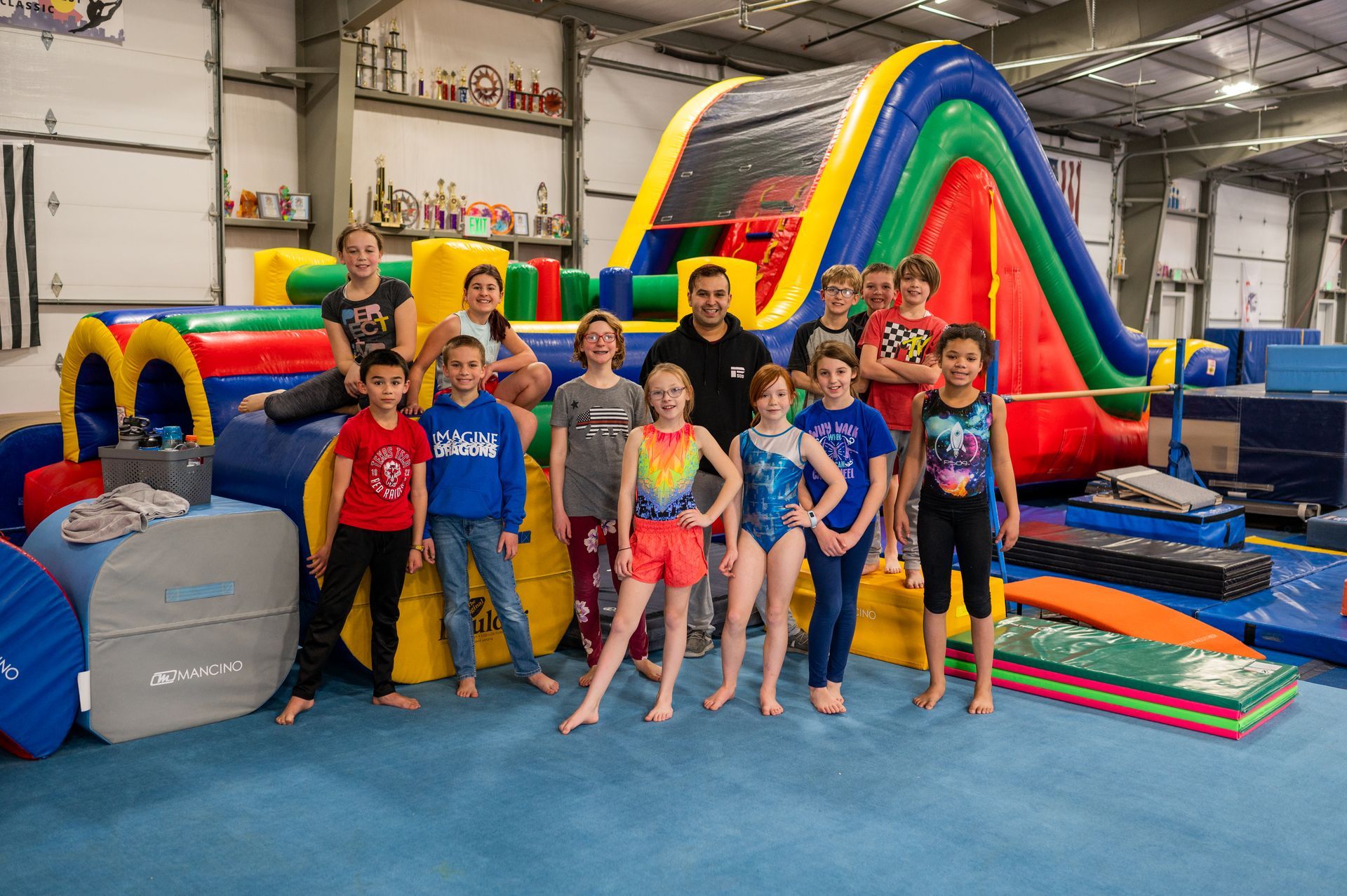 A group of children are posing for a picture in front of a large inflatable slide.