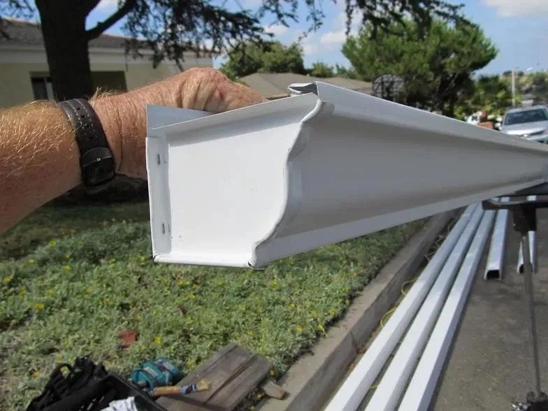 A person is holding a white gutter in their hand