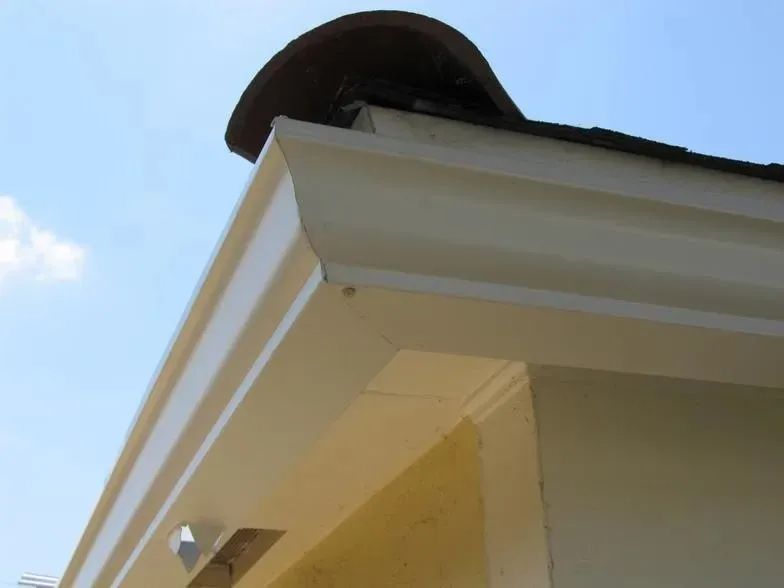 A white gutter on the side of a building