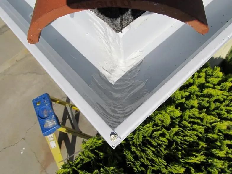 A gutter with a roof tile on top of it