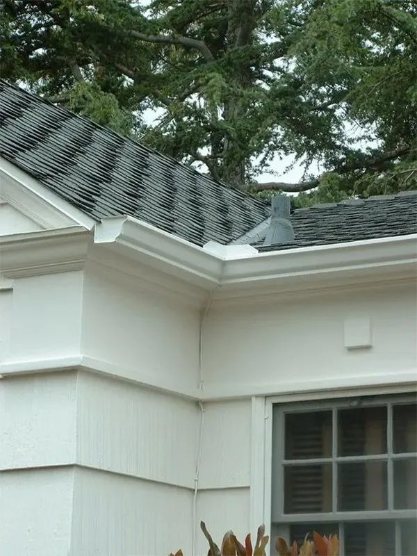 A white house with a black roof and a window