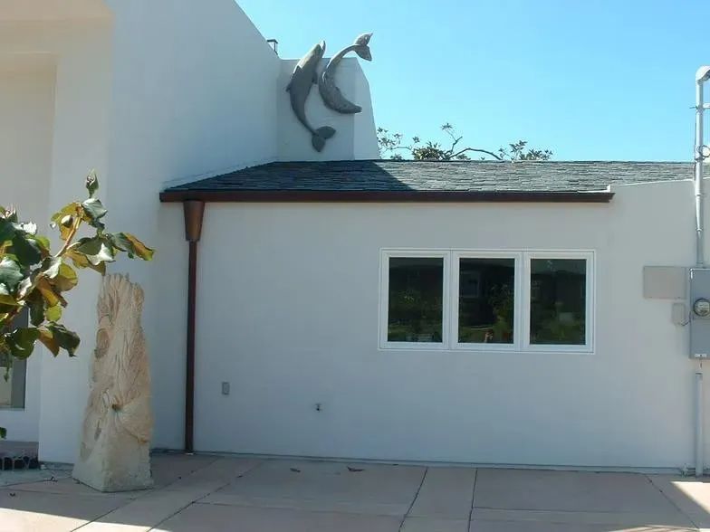 A white house with two dolphins on the side of it