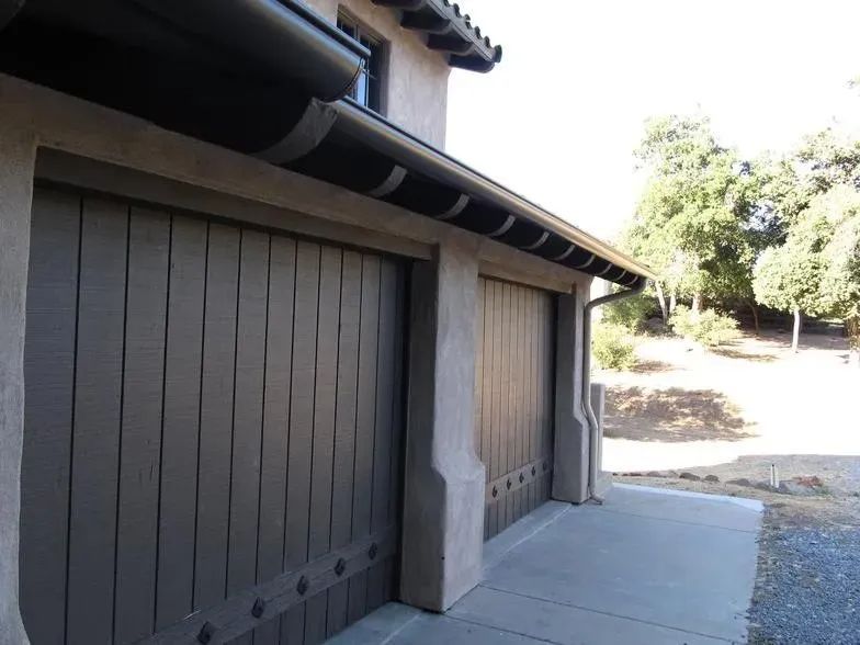 A garage door with a gutter on the side of it