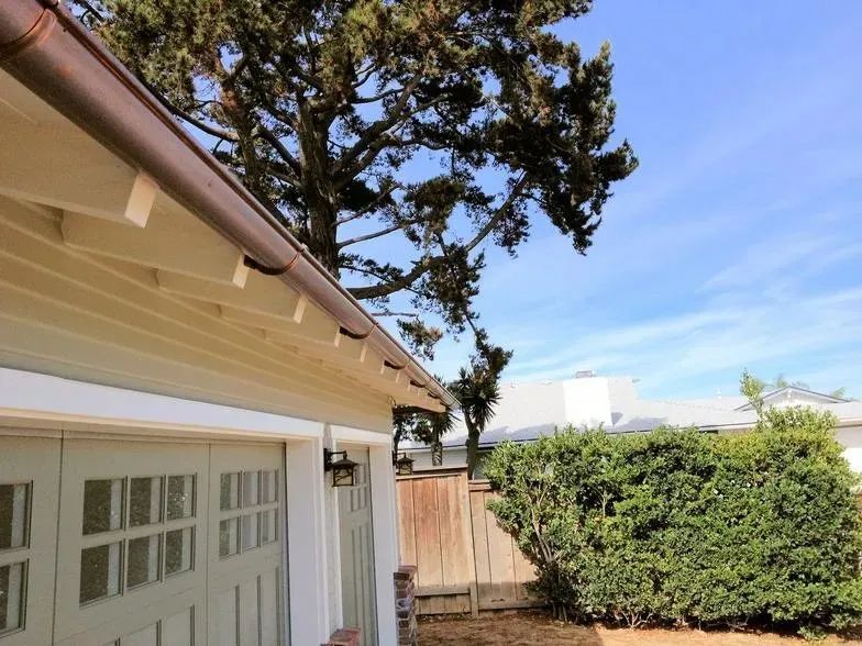 A house with a garage and a tree in the background