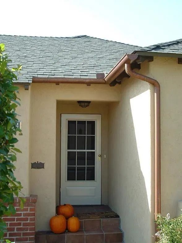 The front door of a house with pumpkins on the steps
