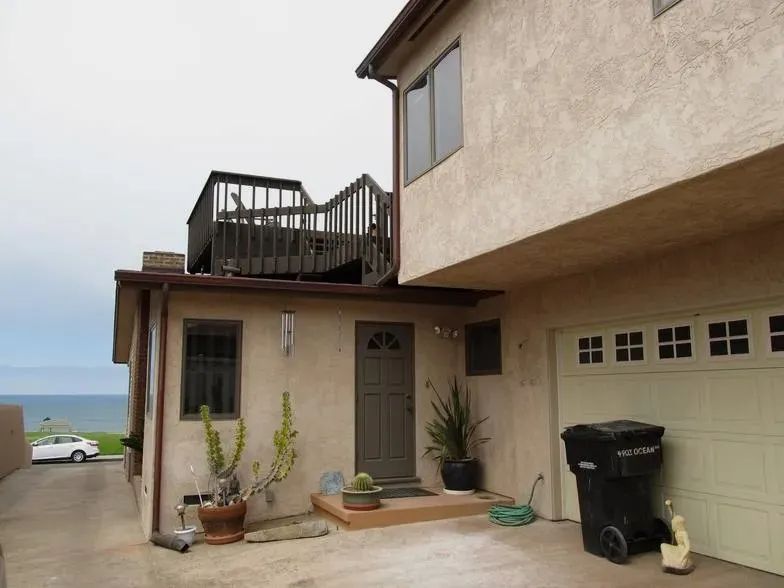 A house with a garage and a balcony overlooking the ocean