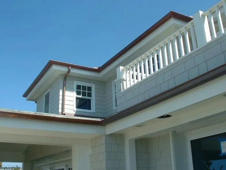 A house with a balcony and a blue sky in the background