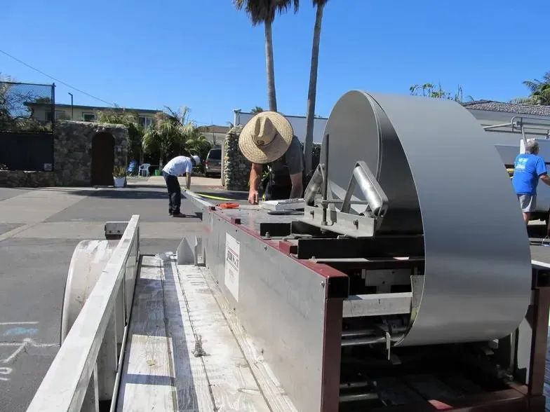 A man wearing a hat is working on a machine