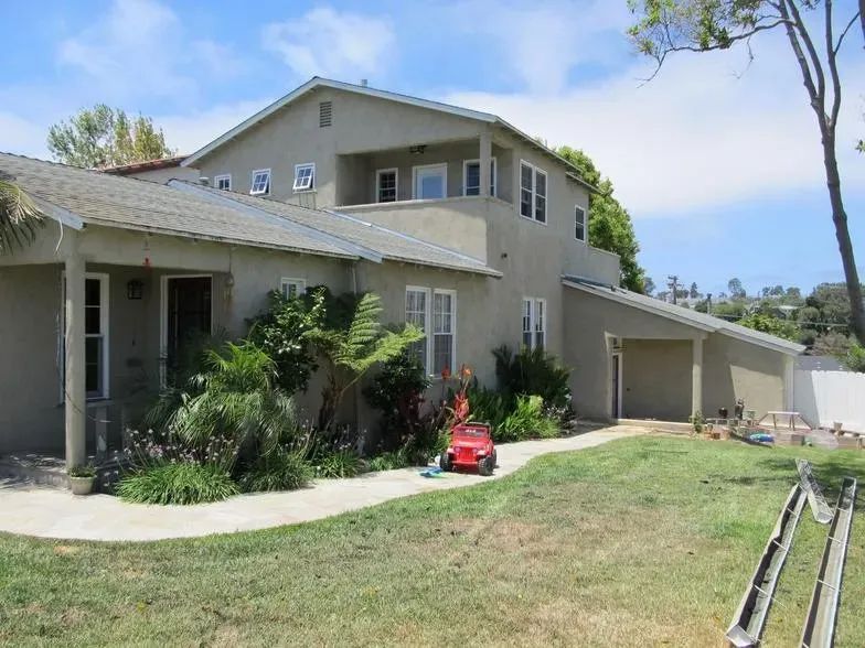 A large house with a red toy car in front of it