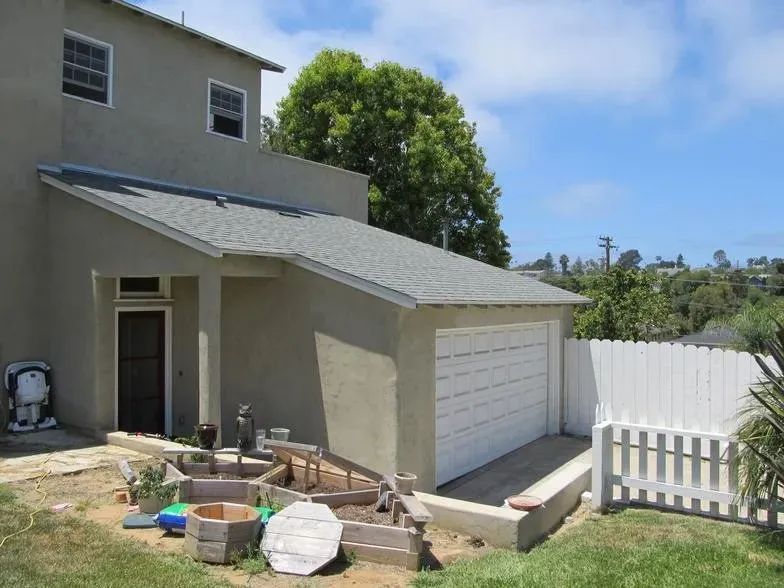 A house with a garage and a fence in front of it