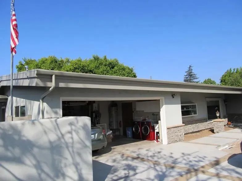 A white house with a red washer and dryer in the garage