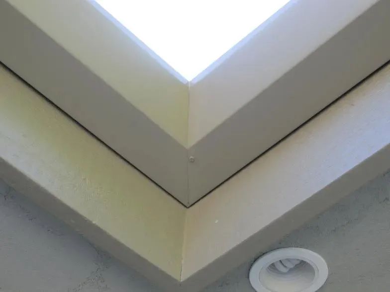 A corner of a ceiling with a light on it