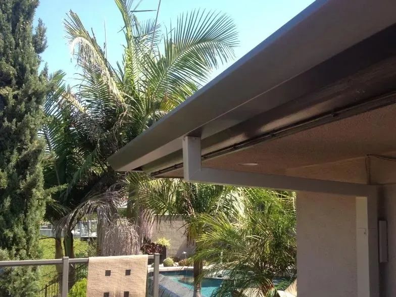 A roof of a house with a pool in the background