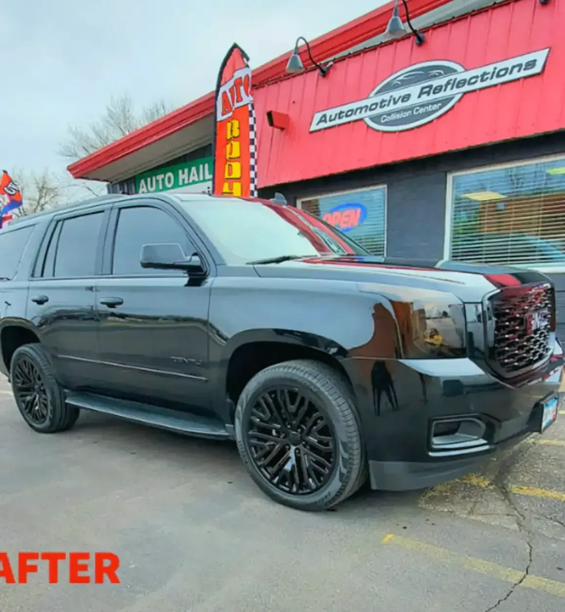 A black GMC SUV parked in front of an Automotive Reflections shop, labeled 