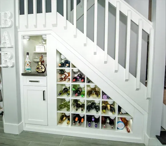 White wine storage and bar built into the space under a staircase.