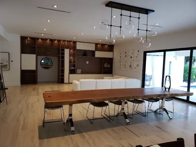 Modern dining room with a large wooden table, seating for 8, and a white sectional.