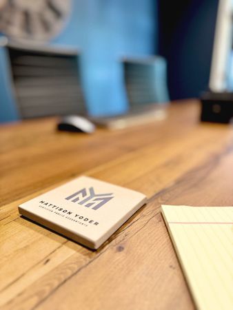 A sticky note with the letter m on it is on a wooden table